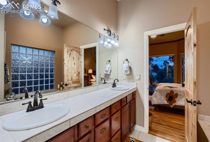 Primary bathroom featuring double sinks, hardwood flooring, and oversized vanity with double sinks