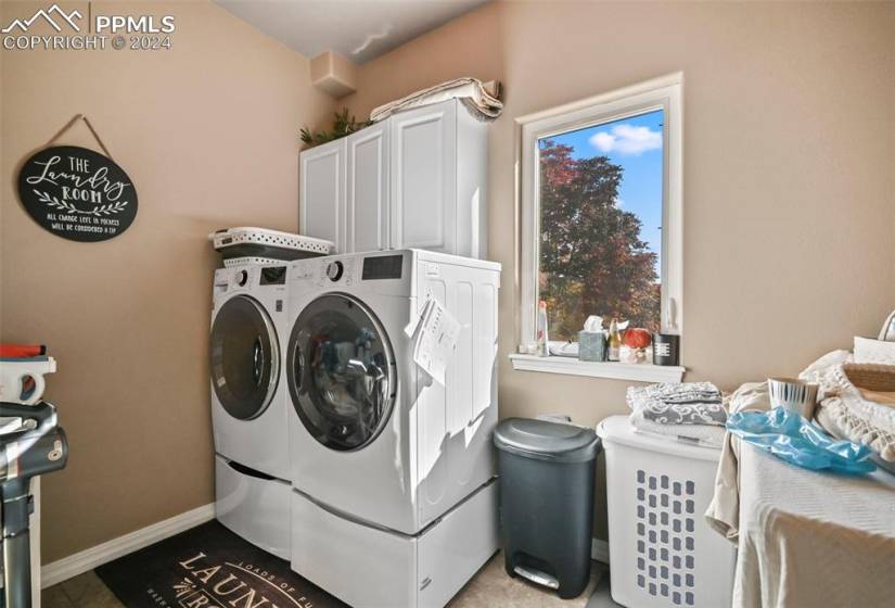 Washroom with cabinets and washing machine and dryer