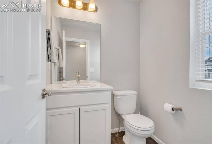 Bathroom featuring hardwood / wood-style flooring, oversized vanity, and toilet