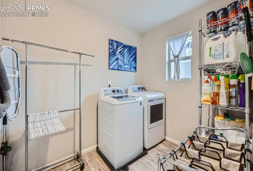 Laundry area featuring light hardwood / wood-style flooring and washing machine and clothes dryer