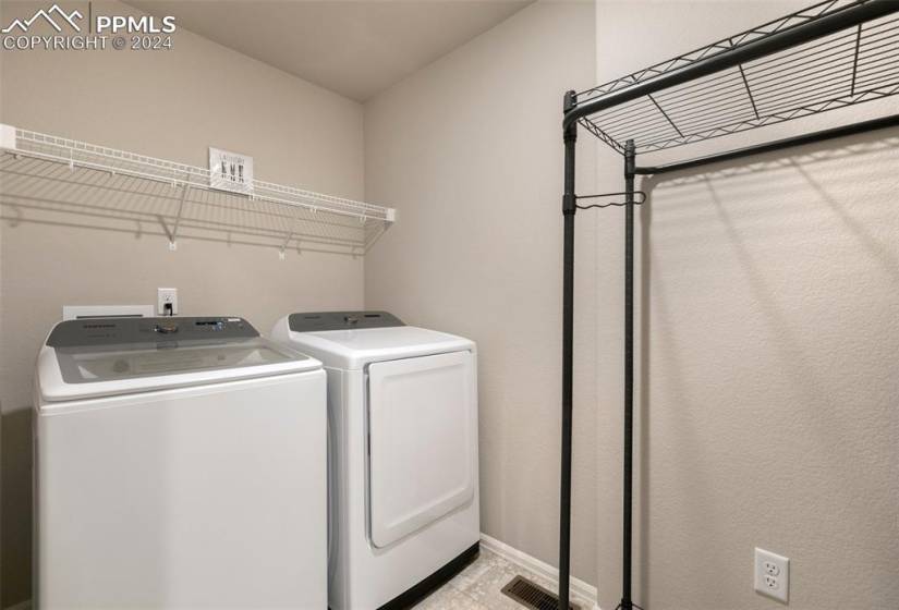Laundry area featuring light tile flooring and washing machine and dryer