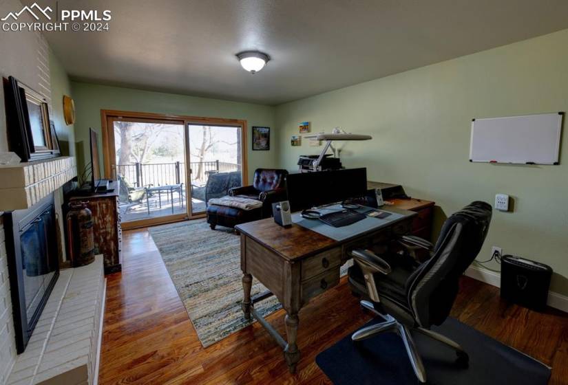 Office area featuring light hardwood / wood-style floors and a brick fireplace
