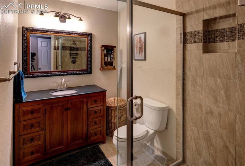 Upstairs bathroom with a shower with door, vanity, and toilet