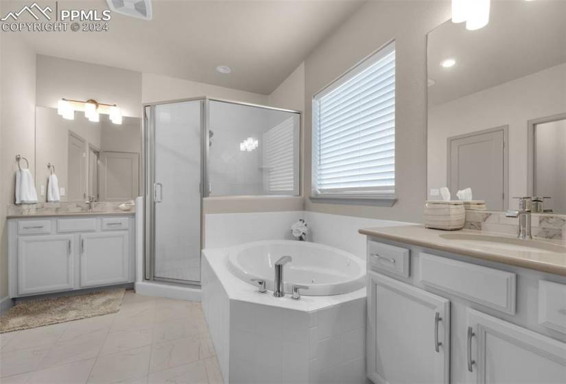 Primary Bathroom with vanity, tile flooring, and stand alone shower and soaking tub