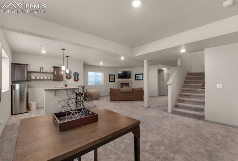 Carpeted basement rec room with wet bar area