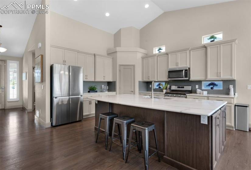 Kitchen with  upgraded quartz stone countertops, a breakfast bar,  custom backsplash, and appliances with stainless steel finishes
