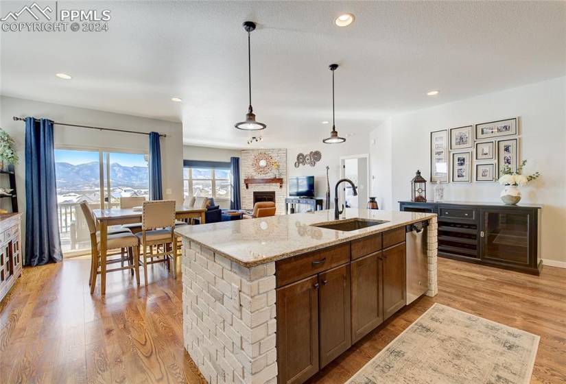 Kitchen with wood floors, Granite counters, island with sink