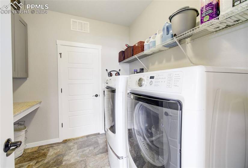 Clothes washing area featuring washing machine and clothes dryer off Master and Hall