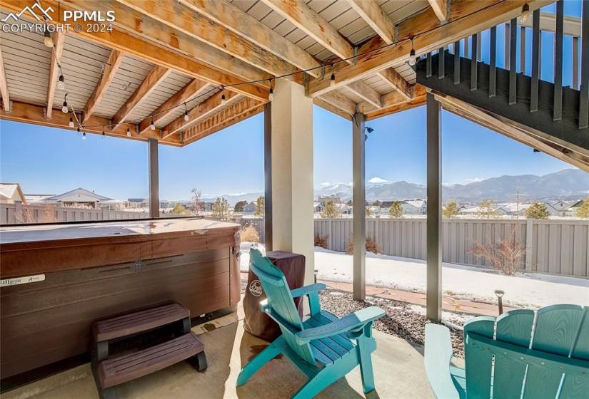 patio with a mountain view and a hot tub located off family room