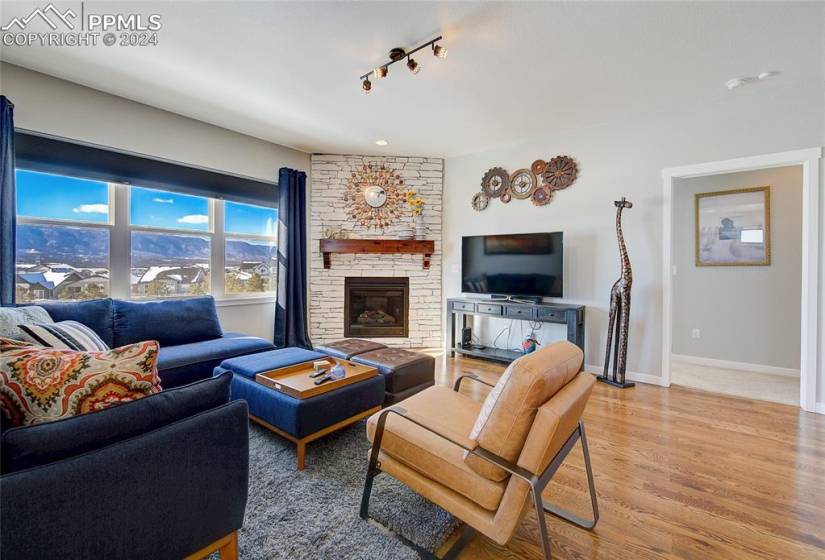 Living room featuring, wood floors, a mountain view, and a stone fireplace