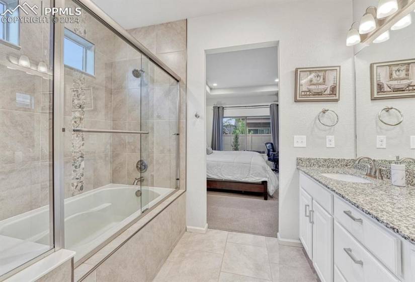 Bathroom with vanity, tile floors, and enclosed tub / shower combo