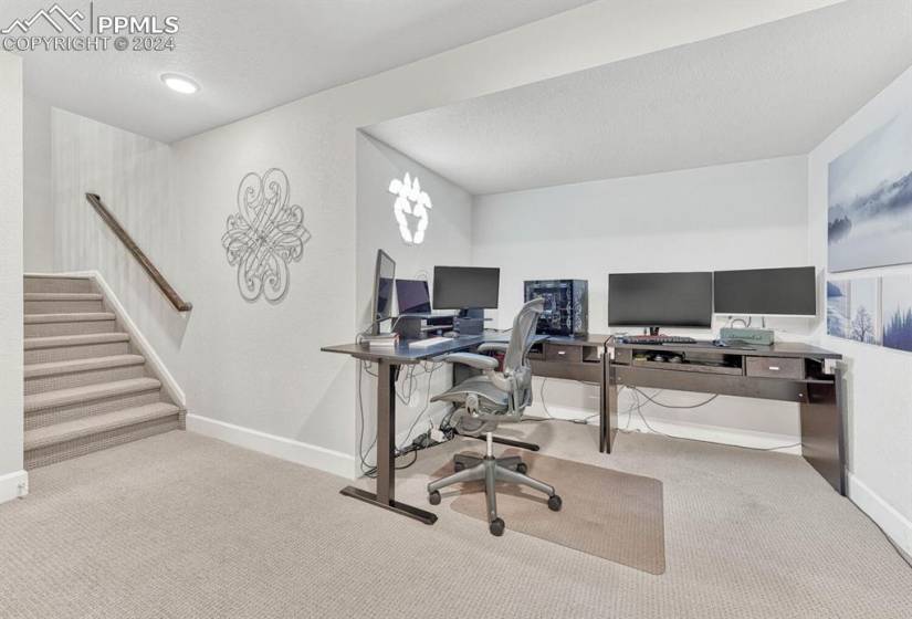 Home office featuring light carpet and a textured ceiling