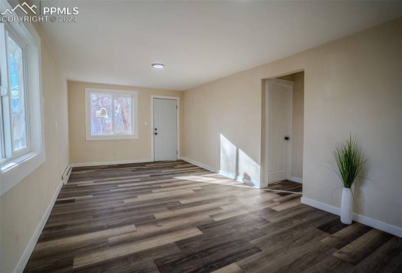 Living room featuring a baseboard heating unit and dark hardwood / wood-style floors