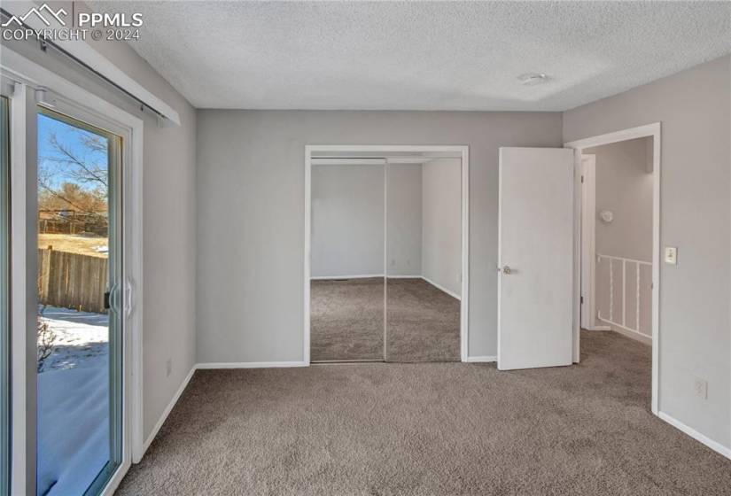 Unfurnished bedroom with a closet, a textured ceiling, and carpet