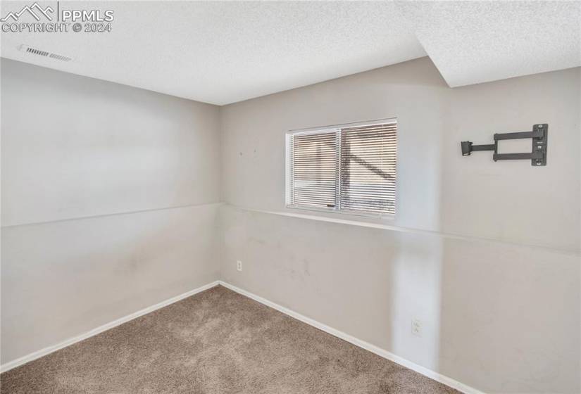 Carpeted spare room with a textured ceiling