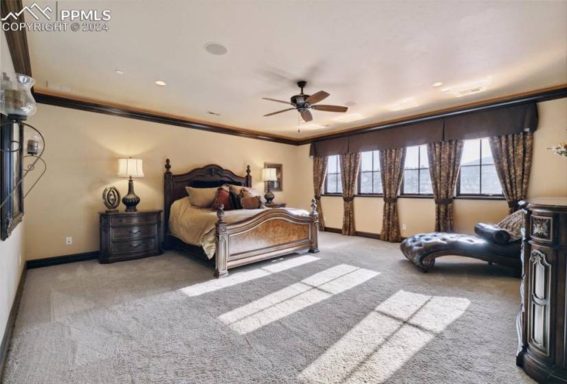 Bedroom featuring crown molding, ceiling fan, and light colored carpet