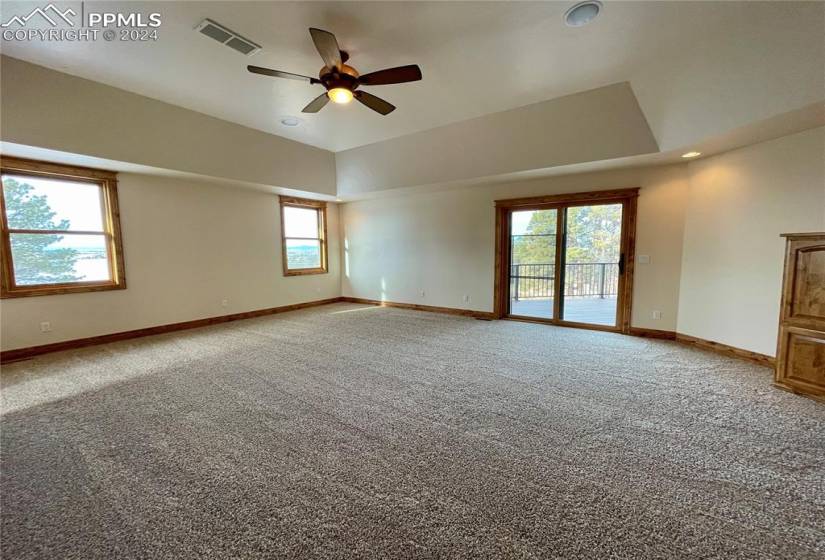 Spare room featuring ceiling fan, light colored carpet, and a tray ceiling