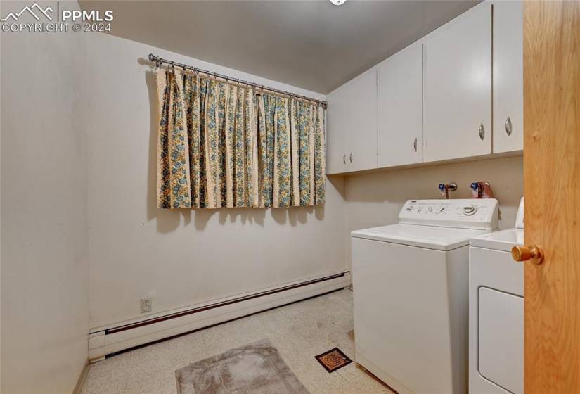 Laundry area featuring washer hookup, cabinets, a baseboard heating unit, light carpet, and separate washer and dryer