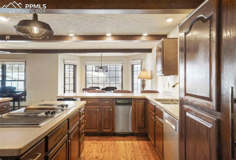Kitchen with sink, light hardwood / wood-style flooring, decorative light fixtures, and appliances with stainless steel finishes