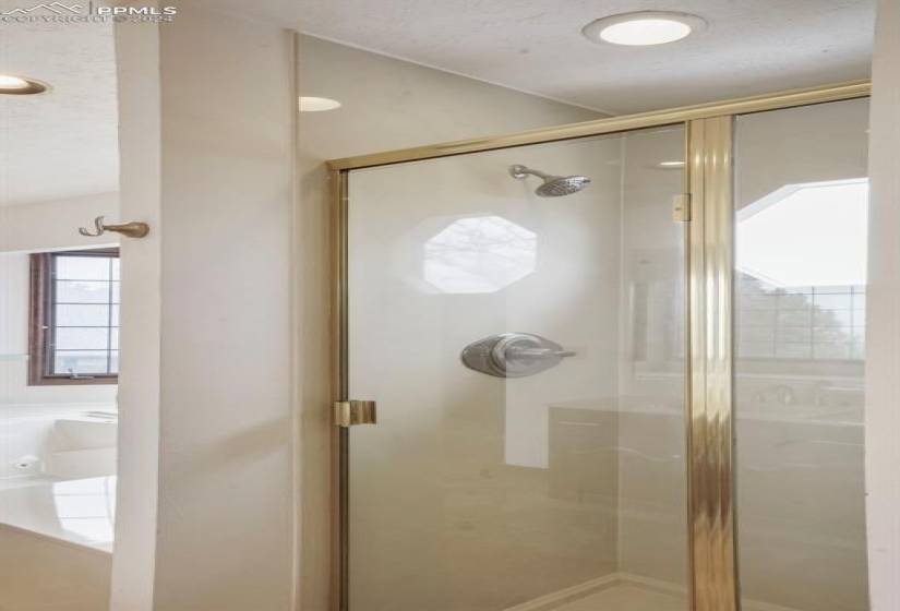 Bathroom featuring shower with separate bathtub and a textured ceiling