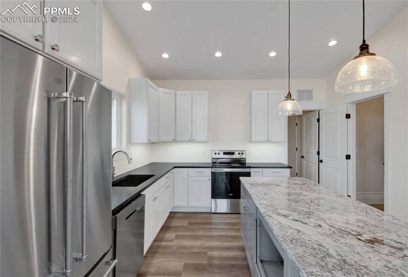 Kitchen featuring white cabinetry, appliances with stainless steel finishes, dark hardwood / wood-style flooring, and sink