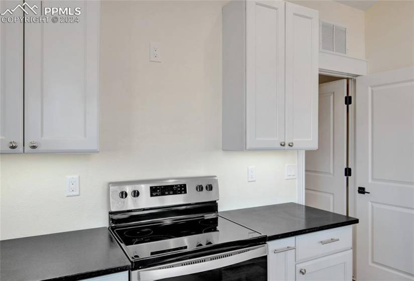 Kitchen with white cabinets and stainless steel electric range