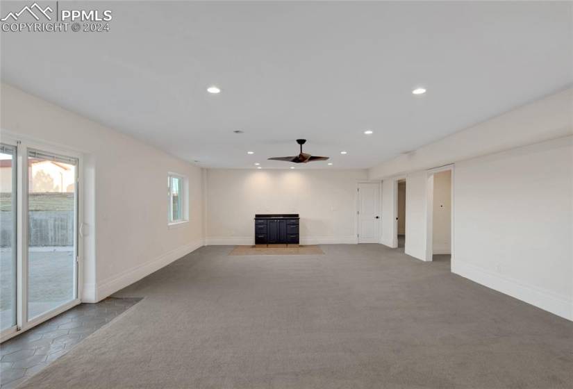 Unfurnished living room with ceiling fan and light colored carpet
