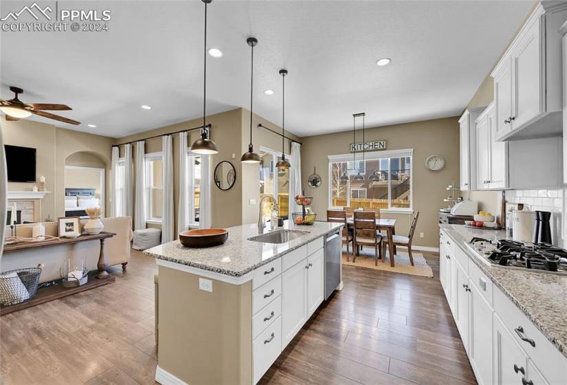 Kitchen with pendant lighting, ceiling fan, an island with sink, and hardwood / wood-style flooring
