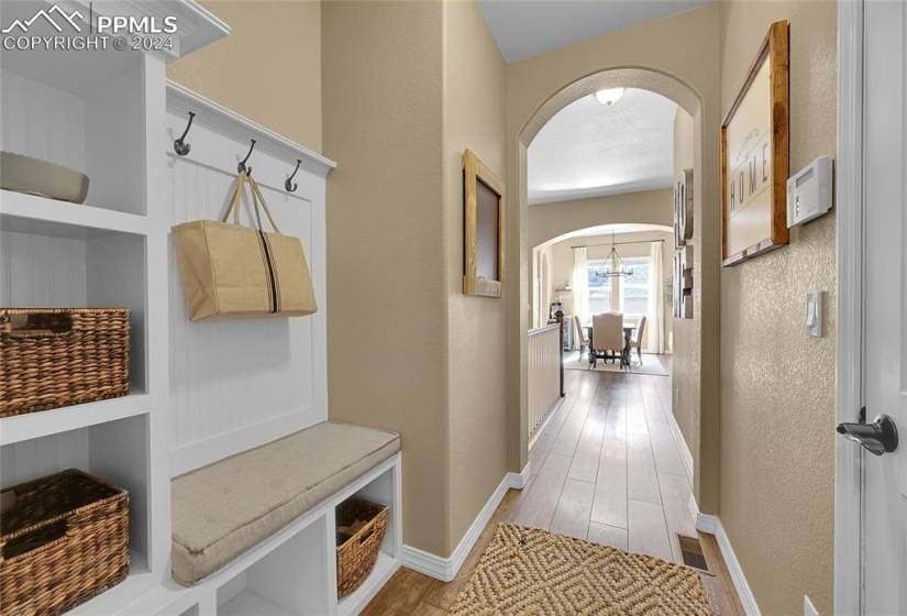 Mudroom featuring light hardwood / wood-style floors and a notable chandelier