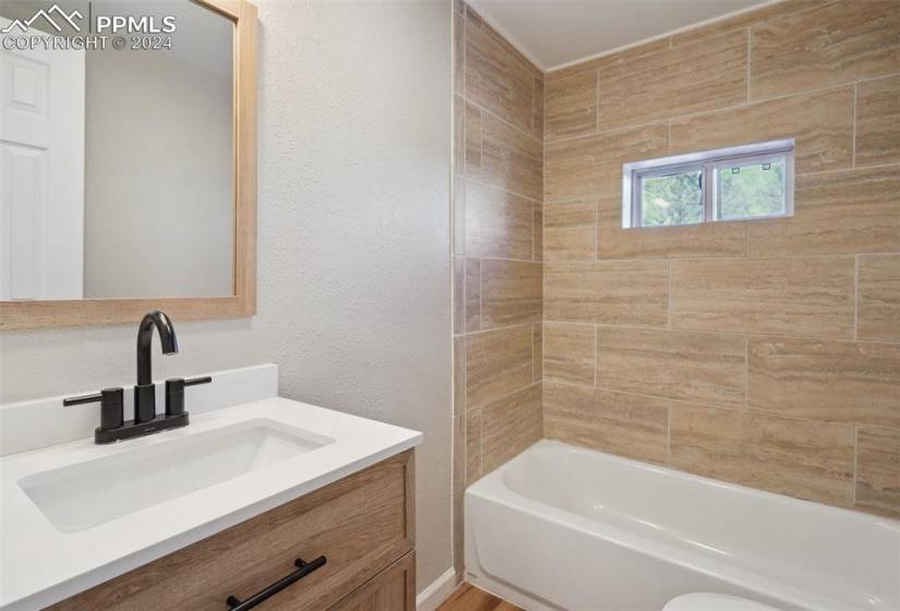 Bathroom featuring tiled shower / bath and vanity with extensive cabinet space