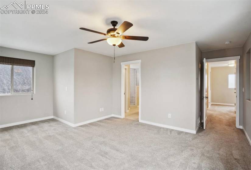 Unfurnished room featuring a healthy amount of sunlight, ceiling fan, and light colored carpet