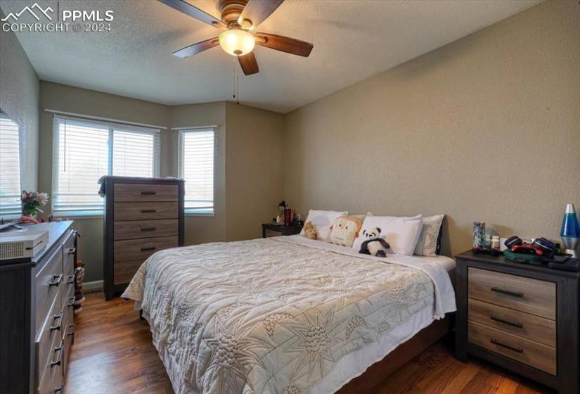 Upper Level Bedroom #2 has wood laminate floors and a lighted ceiling fan.