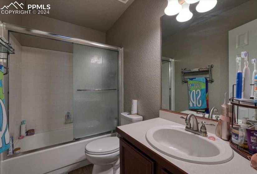 Upper Level Hall Bathroom w/ vanity, mirror, and enclosed tub/shower.