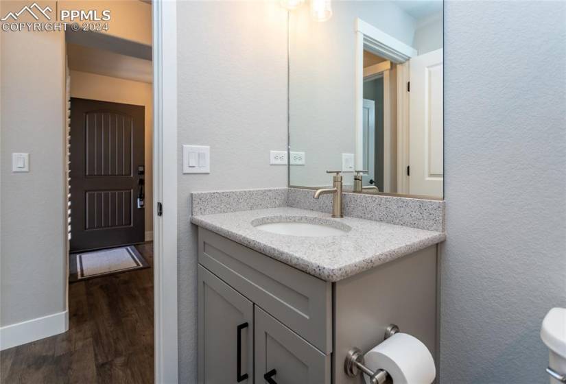 Bathroom with toilet, hardwood / wood-style floors, and vanity with extensive cabinet space