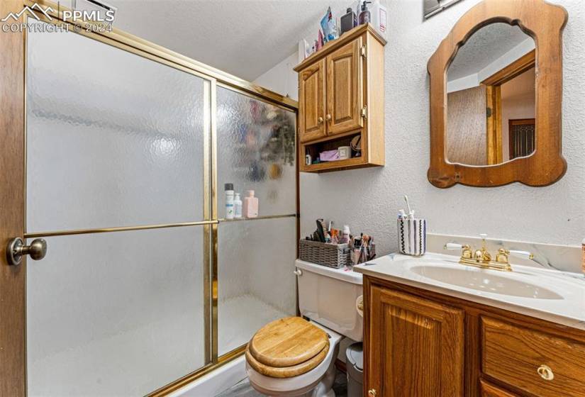 Bathroom featuring vanity, walk in shower, and toilet
