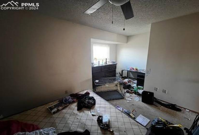 Misc room featuring ceiling fan, a textured ceiling, and tile flooring