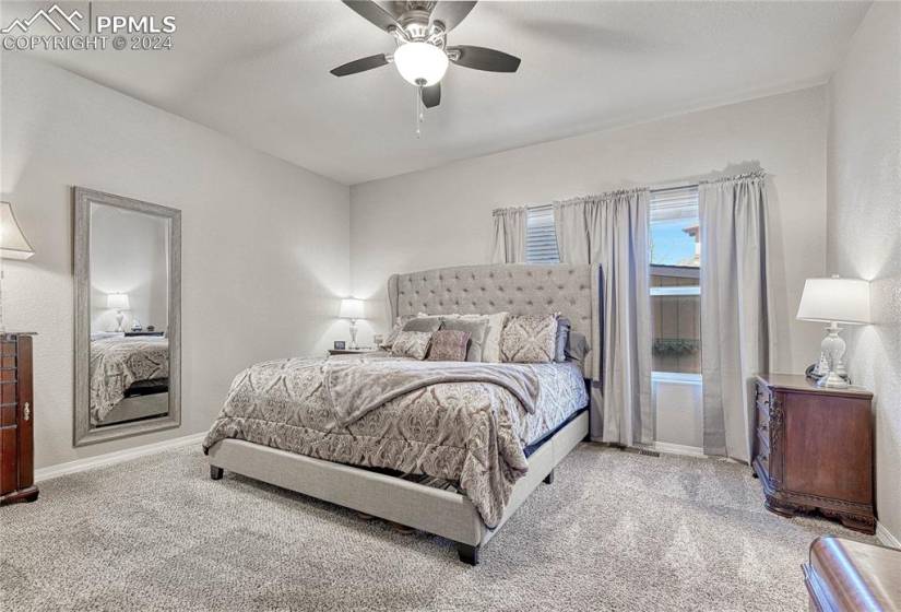 Carpeted bedroom featuring ceiling fan