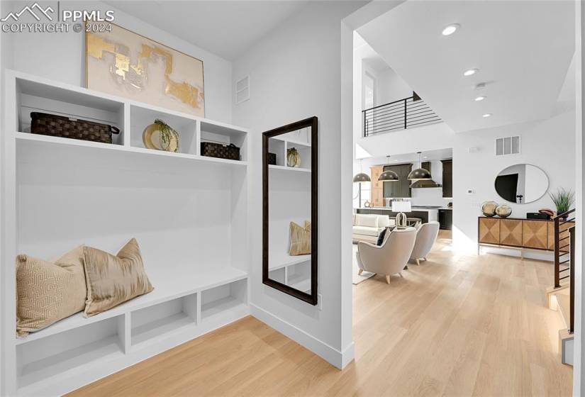 Mudroom featuring light hardwood / wood-style floors and a high ceiling
