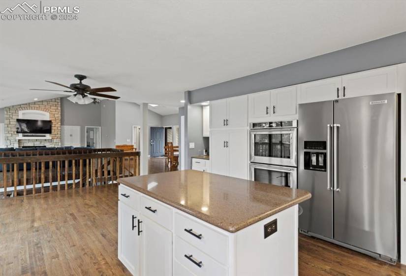 Kitchen featuring hardwood floors, stainless steel appliances and view of living room.