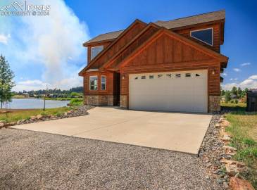 View of front of property with a water view and a garage