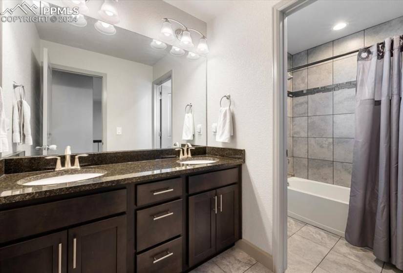 Upper Level Full Hall Bathroom w/ tile floor, dual sink vanity, and tiled tub/shower.