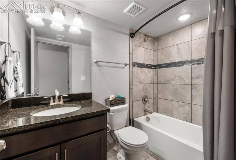 Basement Full Bathroom w/ vanity, mirror, and tub/shower.