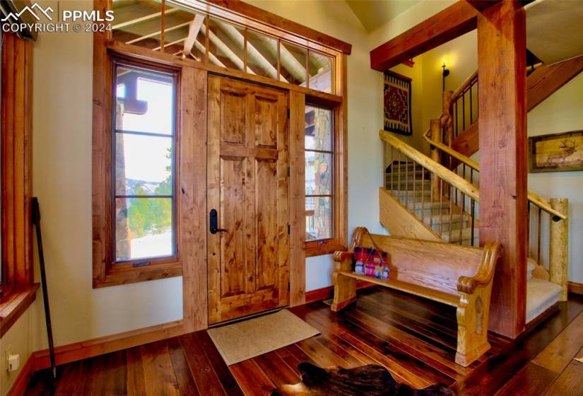 Entryway with lofted ceiling with beams, dark hardwood flooring, and a healthy amount of sunlight