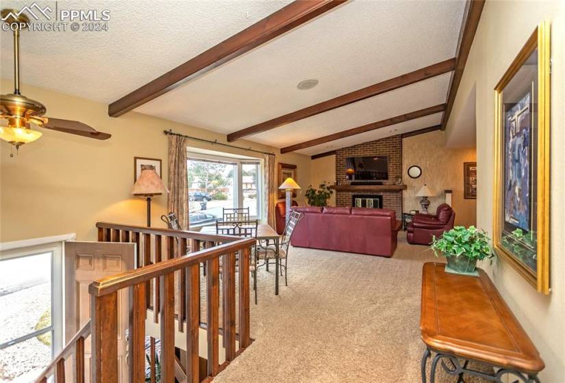 Spacious Great Room with lofted ceiling with beams and brick gas Fireplace
