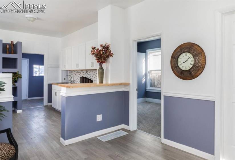 Kitchen with white cabinetry, hardwood / wood-style floors, and a healthy amount of sunlight