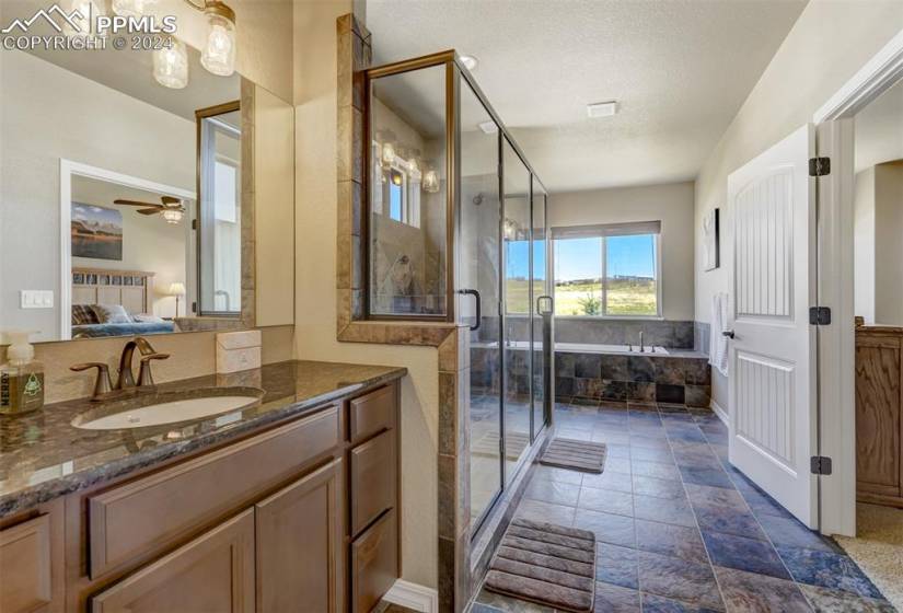 Bathroom with tile flooring, ceiling fan, vanity, and separate shower and tub