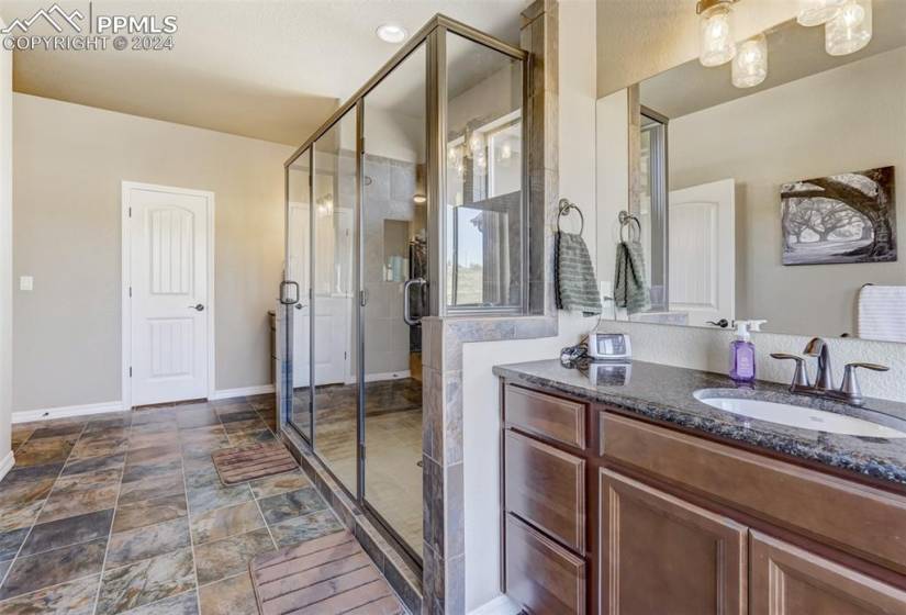 Bathroom with tile flooring, vanity, and a shower with shower door