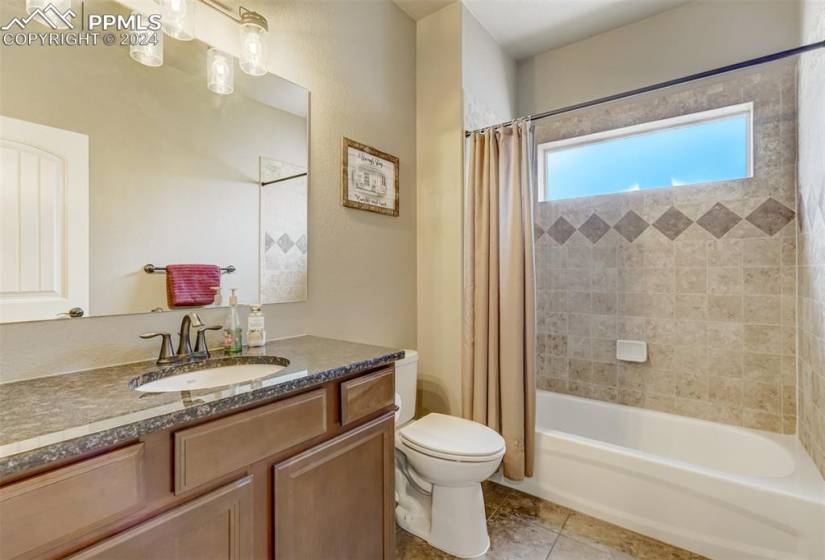Full bathroom featuring shower / bath combo, vanity, toilet, and tile flooring