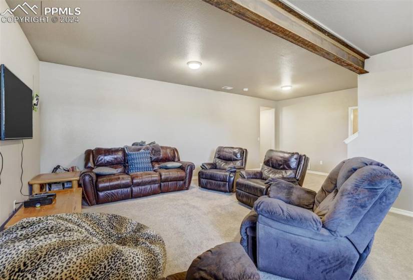 Carpeted living room featuring beam ceiling