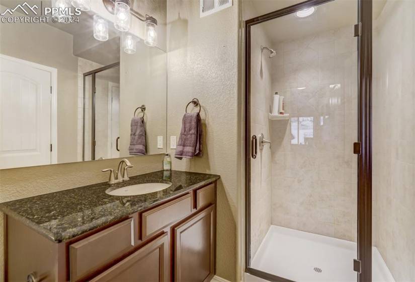 Bathroom featuring vanity and a shower with door